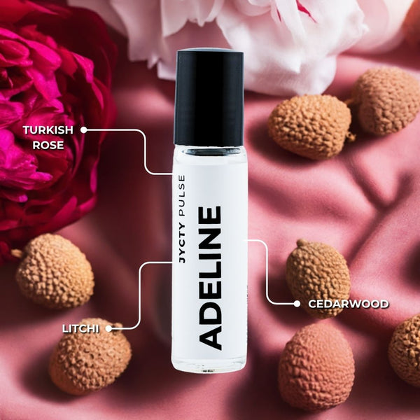Adeline perfume bottle with floral and fruit elements on a pink background