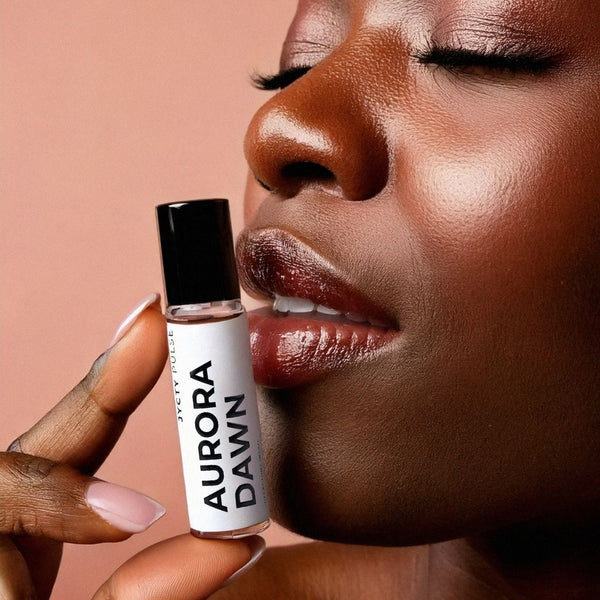 Person holding a 'Aurora Dawn'  long-lasting rollerball perfume with a neutral background
