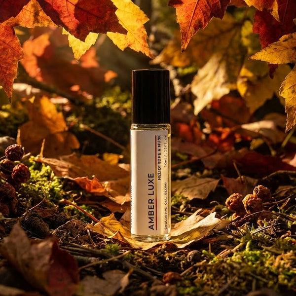 Amber Luxe perfume oil bottle by JYCTY in a natural setting with autumn leaves and pinecones.