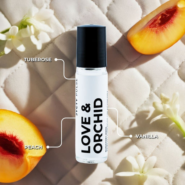 Perfume bottle labeled 'Love & Orchid' with tuberose, peach, and vanilla elements on a textured surface.