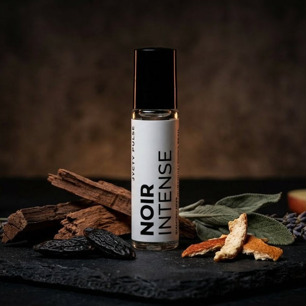 perfume oil bottle labeled 'Noir Intense' surrounded by dried herbs and spices on a dark surface. vegan and long lasting oil by JYCTY perfumery