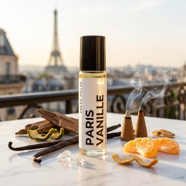 Roll-on perfume bottle labeled 'Paris Vanille' with vanilla beans, oranges, and a smoking pipe on a rooftop with the Eiffel Tower in the background.