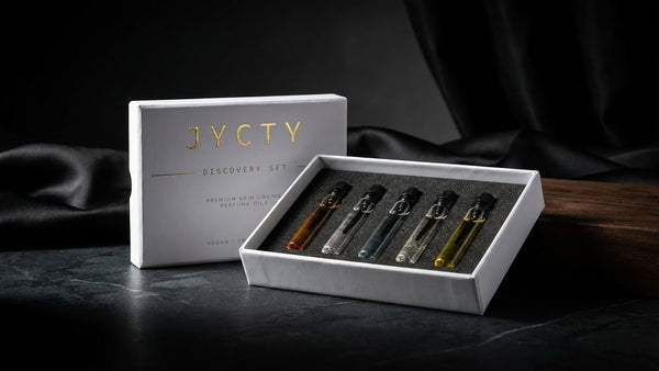 JYCTY discovery set with five small perfume oil bottles on a dark surface