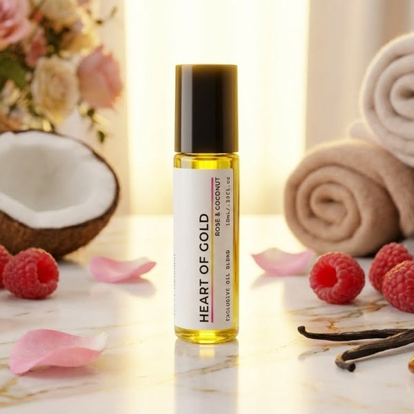 perfume oil Roller bottle labeled 'Heart of Gold' with coconuts, roses, and raspberries on a decorative background.